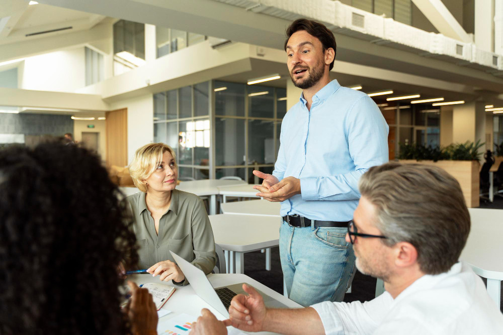 Líder conversando com a equipe em ambiente de trabalho colaborativo, ilustrando gestão de pessoas orientada a resultados.