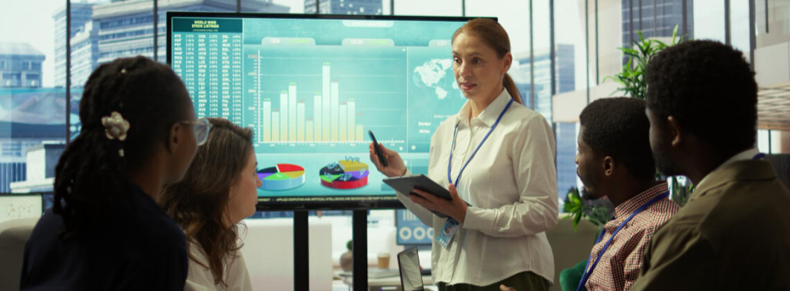 Executivos analisando gráficos de desempenho em um painel, simbolizando a gestão orientada por resultados.