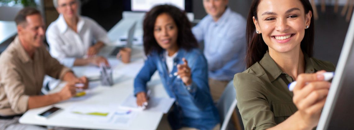Líderes em uma sala de treinamento discutindo gráficos de desenvolvimento profissional e modelos de feedback.