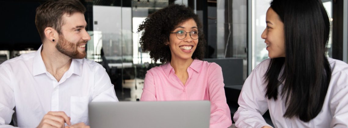 Equipe de profissionais corporativos diversificada em reunião de negócios, conversando de forma entrosada, colaborativa e segura em um escritório moderno representando o engajamento de colaboradores
