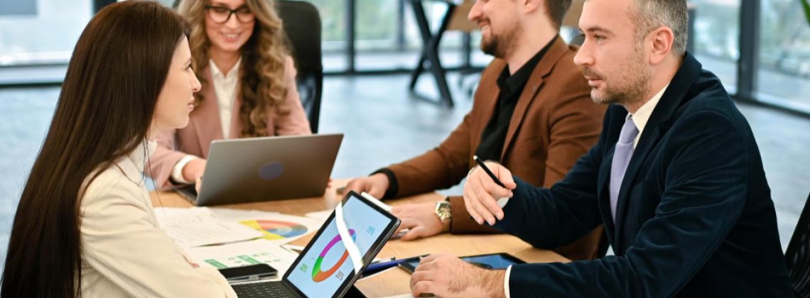 Equipe de liderança corporativa reunida em uma mesa de escritório analisando dados e discutindo o planejamento estratégico e a cultura da empresa.