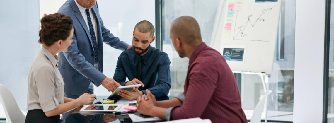 Executivos em reunião estratégica analisando dados, representando a eficácia da liderança organizacional na condução de resultados e transformação cultural.