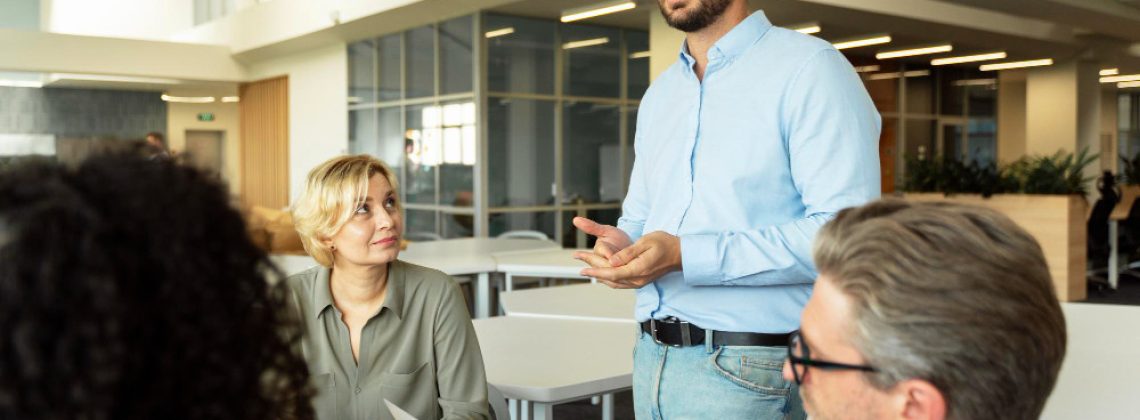 Líder conversando com a equipe em ambiente de trabalho colaborativo, ilustrando gestão de pessoas orientada a resultados.