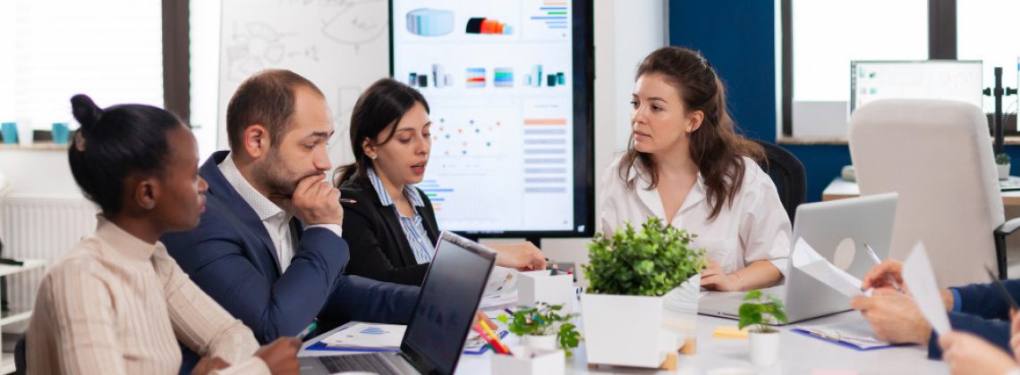 Equipe de executivos analisando dados em uma reunião, representando a importância da cultura organizacional para o sucesso da estratégia.